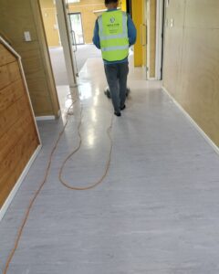 Triple Star Commercial Cleaning team working on hard floor cleaning in a hallway.