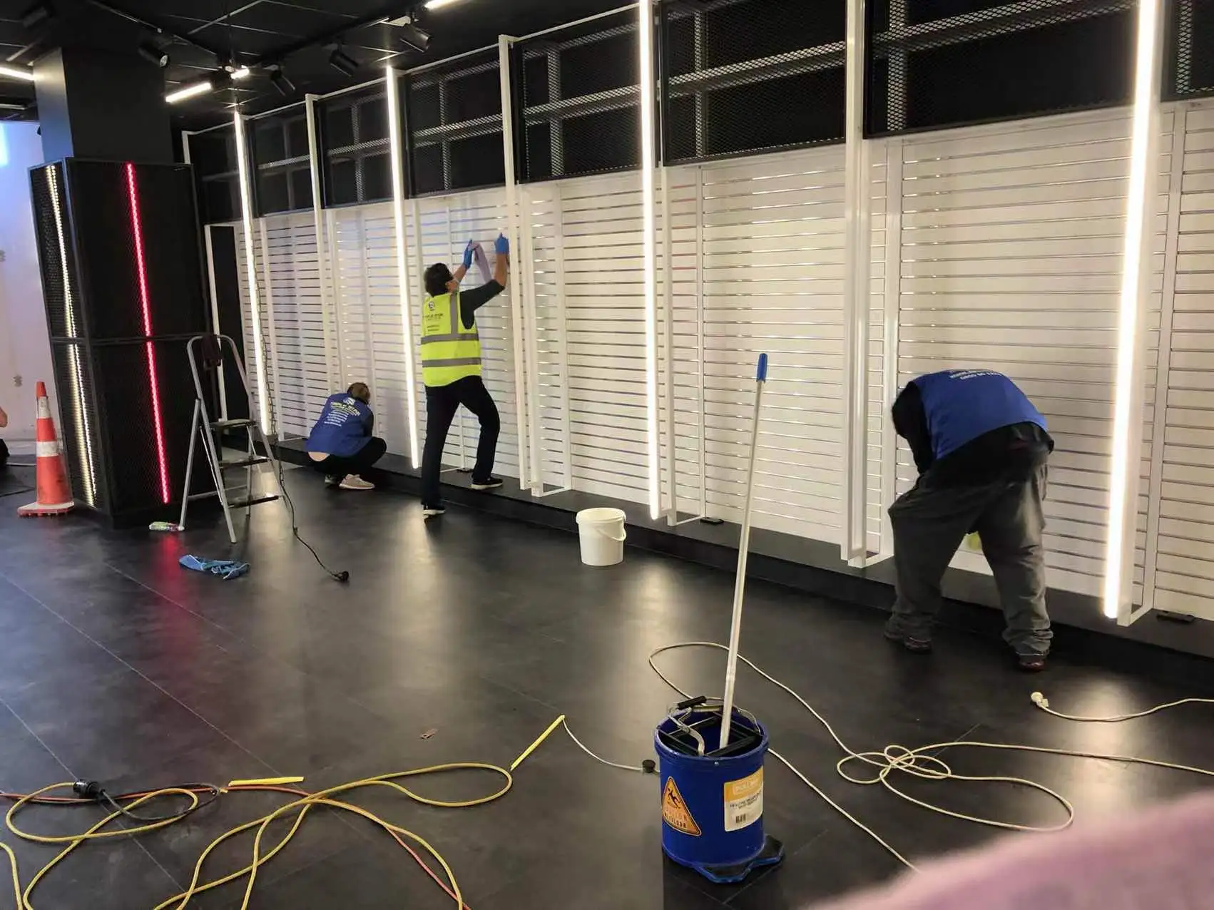 A team of professional cleaners performing post-construction cleaning in a commercial space, ensuring walls and floors are spotless.