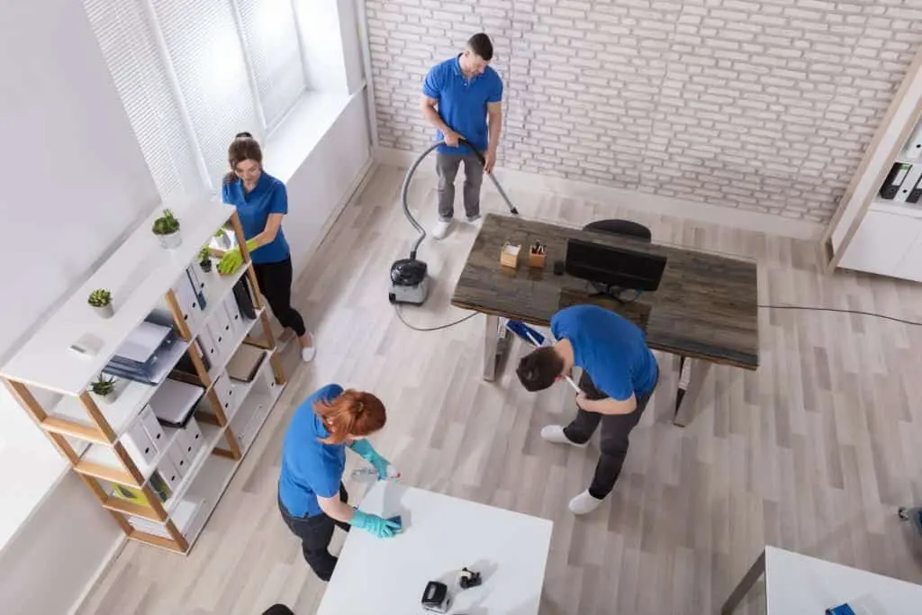 A team of professional cleaners performing a thorough end-of-tenancy cleaning in a modern office space.