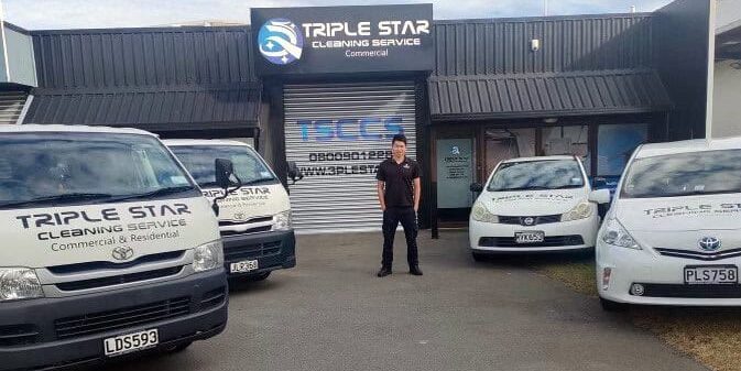 Triple Star Commercial Cleaning headquarters with branded company vehicles and a team member standing proudly in front of the building.