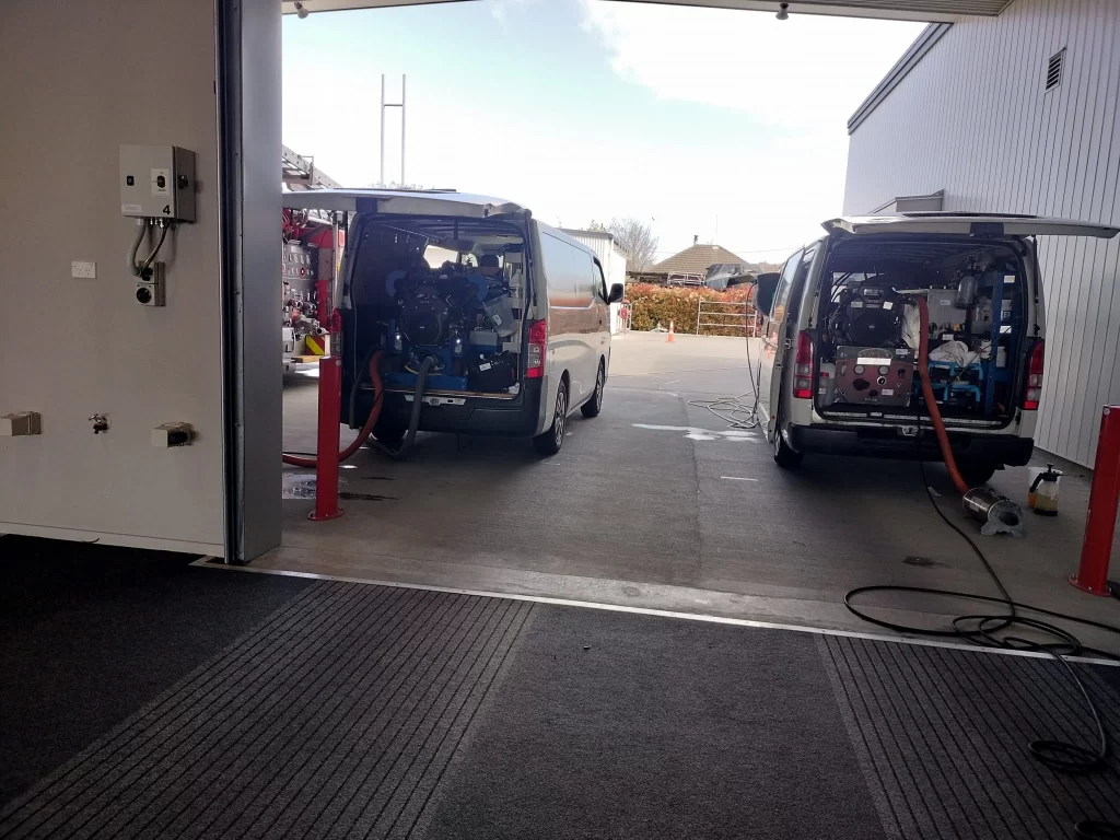 Professional truck-mounted carpet cleaning equipment set up in service vans for large-scale commercial cleaning projects.