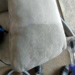 Professional upholstery cleaning on a sofa cushion with visible cleaning results.