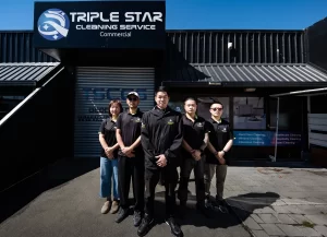 Team of professionals in Triple Star Commercial Cleaning uniforms standing in front of the company's office in Christchurch.